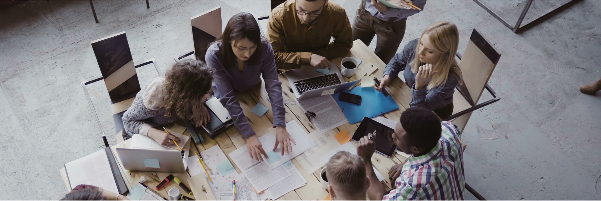 A large team collaborates over a table.