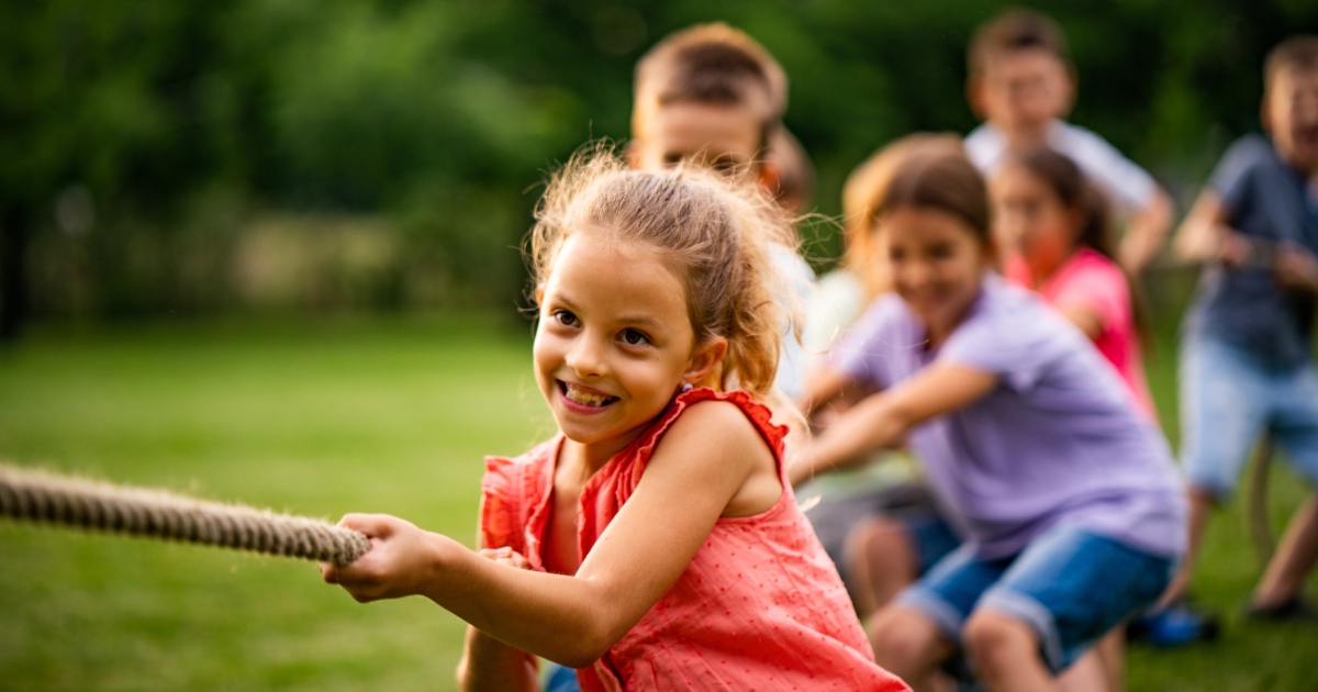 Happy kids pulling a rope in park James Bell Associates James Bell