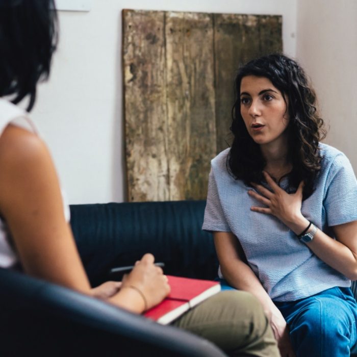 A woman speaks to a counselor.