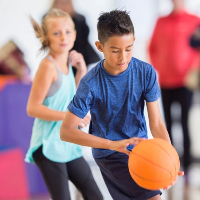 A boy bounces a basketball.