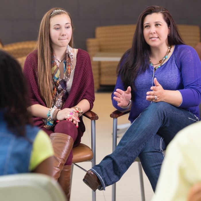 A woman speaks at a group class.